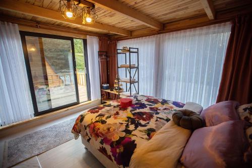 a bedroom with a bed and a couch and a window at TERAPİ TATİL KÖYÜ in Rize