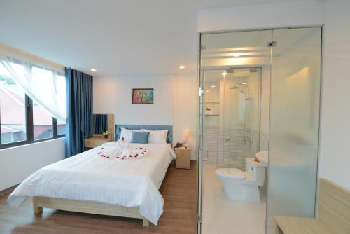 ein Schlafzimmer mit einem Bett, einer Dusche und einem WC in der Unterkunft Hanoi Prime Garden Hotel & Spa in Hanoi