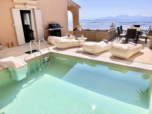 a swimming pool with pillows sitting next to a house at Luxury Villa Azur Natura with private pool by DadoVillas in Spartýlas