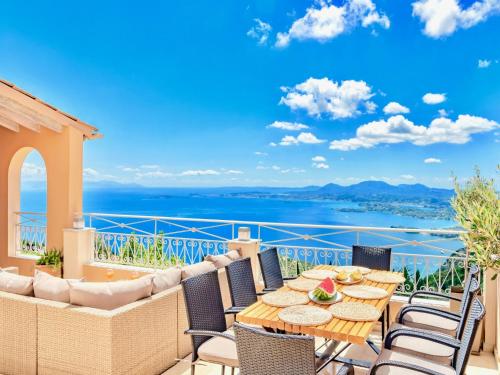 a patio with a table and chairs and a view of the ocean at Luxury Villa Azur Natura with private pool by DadoVillas in Spartýlas
