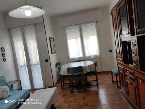 a living room with a table and chairs and windows at Da Francesca in Scardovari