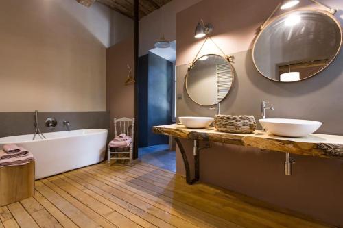 y baño con 2 lavabos, bañera y espejo. en Château de Villeclare - 2 nuits minimum, en Palau-del-Vidre