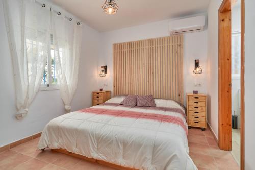 Un dormitorio con una cama grande y una ventana. en Tower House, en Cómpeta