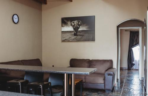 a living room with an elephant painting on the wall at Casa Leitao Lodge in Phalaborwa