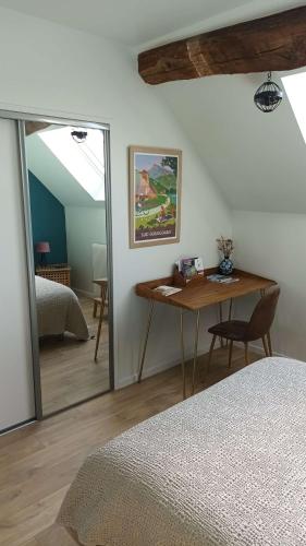 a bedroom with a desk and a bed and a mirror at Le Verger de Massilly in Massilly