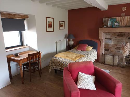 una camera con letto, tavolo e sedia di Le Verger de Massilly a Massilly