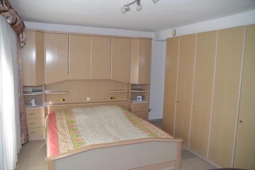 - une chambre avec un lit et des placards en bois dans l'établissement Monis Home, à Stühlingen