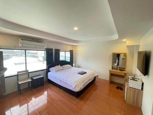 - une chambre avec un lit et une télévision dans l'établissement The Sports Lounge, à Pattaya