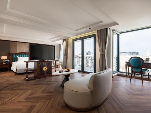 una camera d'albergo con letto e TV di L'Signature Hotel & Spa a Hanoi