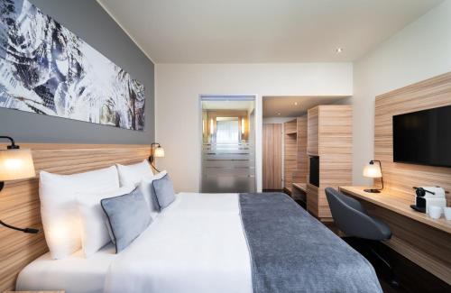 um quarto de hotel com uma cama e uma televisão de ecrã plano em Leonardo Hotel Vienna Hauptbahnhof em Viena