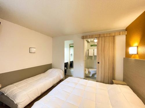 1 dormitorio con 2 camas y baño en Hotel du Parc - Chantepie, en Chantepie