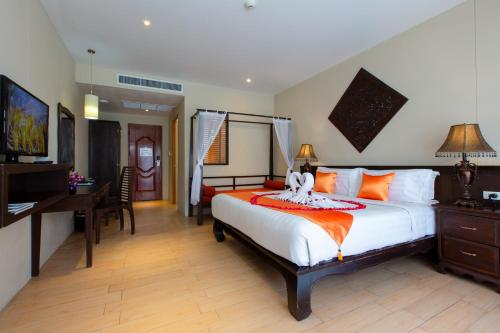 Schlafzimmer mit einem großen Bett, einem Schreibtisch und einem Schreibtisch in der Unterkunft Blue Bay Resort - Near Phuket & Krabi in Ko Yao Yai