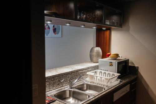 a kitchen counter with a sink and a microwave at Classy 1BR in Al Sahab Dubai Marina in Dubai