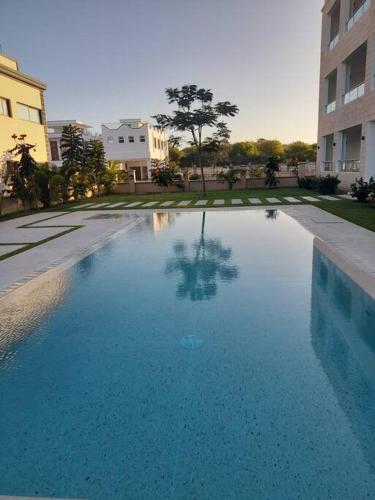 a large blue swimming pool in front of a building at Sandbox Apartment 4 Diani Beach Kenya in Ukunda