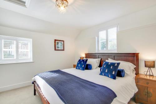 a bedroom with a large bed with blue pillows at Pass the Keys Lovely Countryside Coach Cottage in Tonbridge