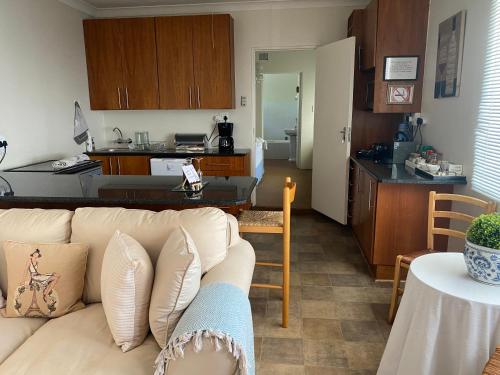 パリスにあるSilver Linings Guesthouseのリビングルーム(白いソファ付)、キッチンが備わります。