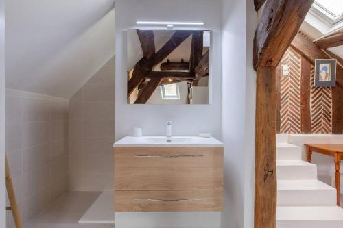uma casa de banho com um lavatório e um espelho em La Reverdie Escapade aux pays des châteaux em Cellettes
