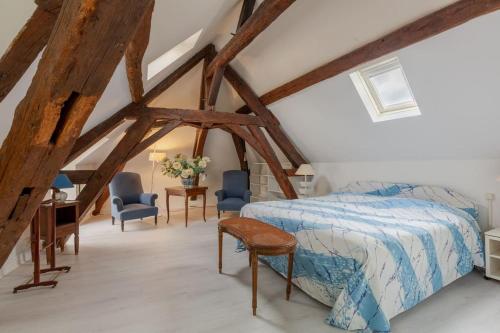 um quarto com uma cama, uma secretária e cadeiras em La Reverdie Escapade aux pays des châteaux em Cellettes