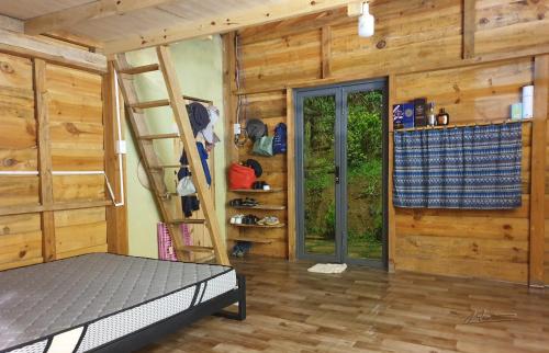 a bedroom with two bunk beds and a door at Tuyên Chiến Home - Nhà Gỗ in Ấp An Kroët