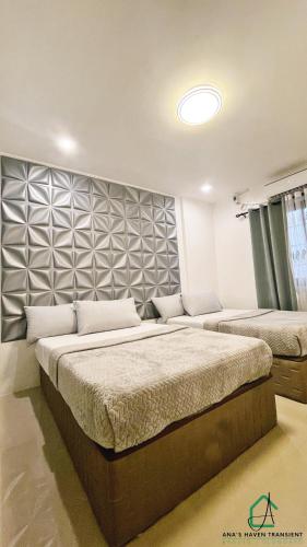 a bedroom with two beds and a wall at Ana's Haven Transient Olongapo Subic 2 East Bajac-Bajac in Olongapo