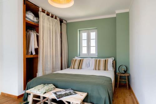 um quarto com paredes verdes e uma cama com uma mesa em Sea´ya Thoughtful Stays - Villa Areia em Cascais