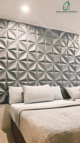 a large bed with a silver padded headboard at Ana's Haven Transient Olongapo Subic 2 East Bajac-Bajac in Olongapo