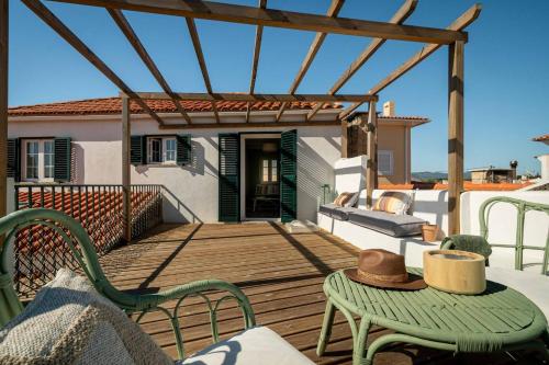 um deque de madeira com cadeiras, uma mesa e uma pérgola em Sea´ya Thoughtful Stays - Villa Areia em Cascais