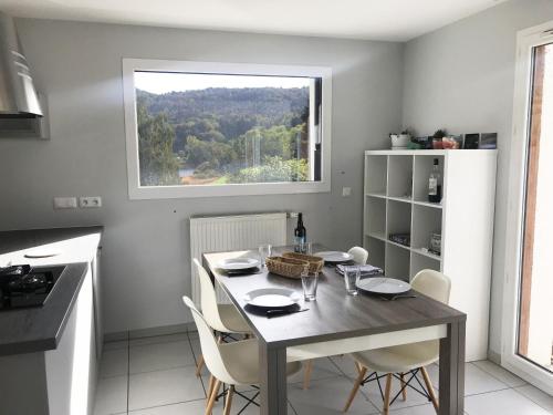 eine Küche mit einem Tisch mit Stühlen und einem Fenster in der Unterkunft Chalet de la Thuile in La Thuile
