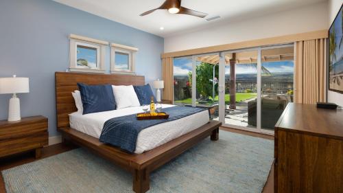 een slaapkamer met een bed en een glazen schuifdeur bij ADVENTURE AWAITS Fun 4BR Ainamalu Home with Private Pool in Waikoloa