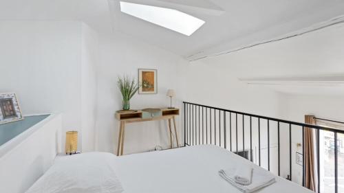 une chambre blanche avec un lit et un balcon dans l'établissement Charmant logement au coeur du cours julien, à Marseille