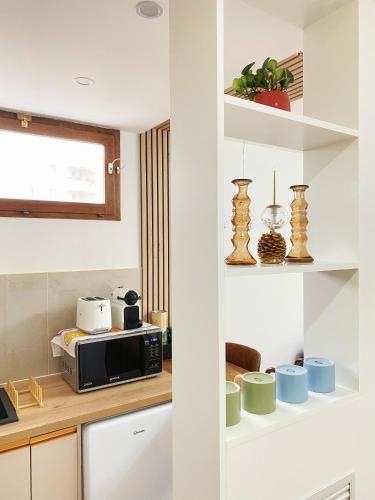 une cuisine avec des armoires blanches et un micro-ondes dans l'établissement Chez les deux garçons, à Montrouge