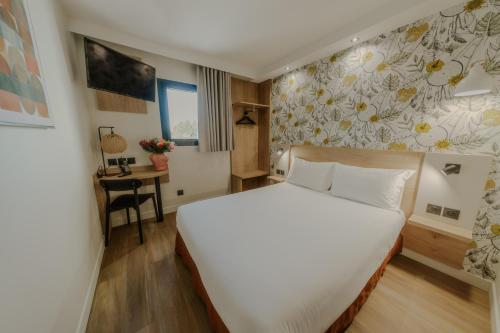 サランにあるKYRIAD DIRECT ORLEANS NORD - Cap Saranのベッドルーム(白い大型ベッド1台、デスク付)