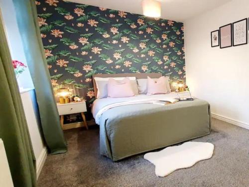 a bedroom with a bed with a floral wall at Pass the Keys Beautifully refurbished house close to Airport in Manchester