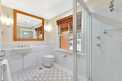 a bathroom with a toilet and a sink and a shower at Villa 2br Albarino Villa located within Cypress Lakes Resort in Pokolbin