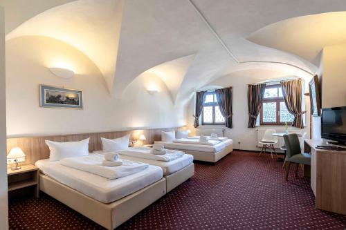 a hotel room with two beds and a television at Hotel Alter Wirt in Weyarn