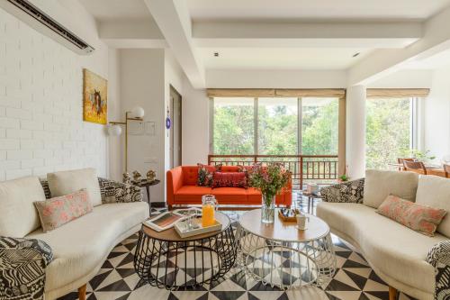 a living room with couches and a table at El Rocio Estate 2bhk in Assagao with Common pool, Free Parking,8 min away from Vagator in Assagao