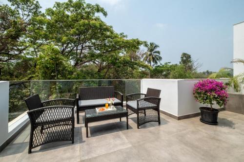 a patio with chairs and a table on a balcony at El Rocio Estate 2bhk in Assagao with Common pool, Free Parking,8 min away from Vagator in Assagao