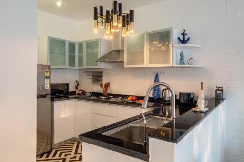 a kitchen with white cabinets and black counter tops at El Rocio Estate 2bhk in Assagao with Common pool, Free Parking,8 min away from Vagator in Assagao