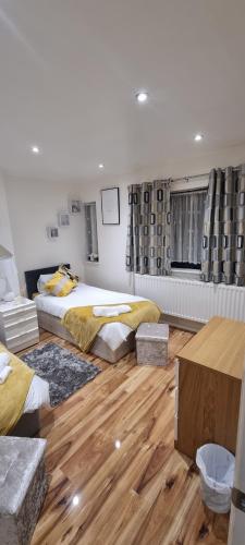 a bedroom with two beds and a wooden floor at Beautiful Rooms with free on street parking in Sydenham in Forest Hill