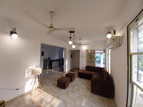 a living room with a couch and chairs and a window at Sukoon Holiday Home in Chinchavli