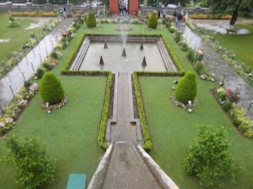 a garden with a fountain in the middle at Hotel City Way, Srinagar in Srinagar