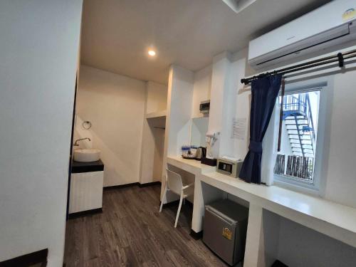 a small room with a desk and a window at Three Trees Samui Resort - Sarocha Villa in Lamai