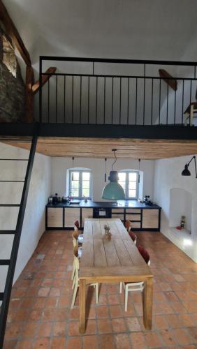 a kitchen with a wooden table and a loft at Ořechový dvůr in Velké Nepodřice