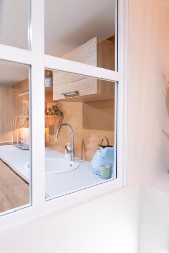 une cuisine avec un évier et une fenêtre dans l'établissement Chaleureux Studio - Centre Ville, Zénith - Wifi, à Caen