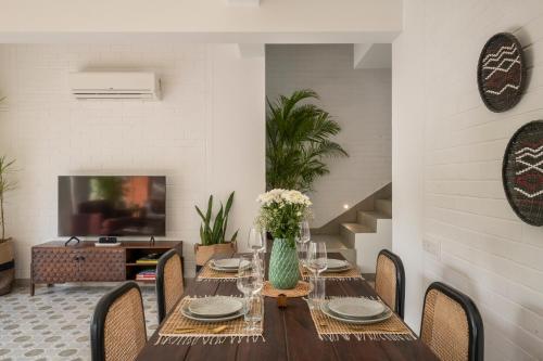 a dining room with a wooden table and chairs at El Rocio Estate 2bhk in Assagao with Common pool, Free Parking,8 min away from Vagator in Assagao