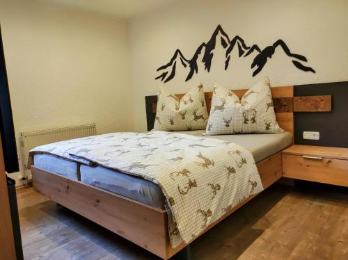 a bedroom with a bed with mountains on the wall at Ferienwohnung Bergzauber in Maurach