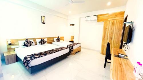a bedroom with two beds and a flat screen tv at HOTEL THE CELEBRATION BY AMOD Best Hotel & Rooftop in Udaipur