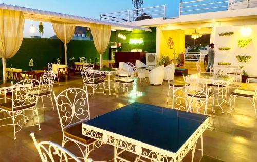 a restaurant with white chairs and tables and a table top at HOTEL THE CELEBRATION BY AMOD Best Hotel & Rooftop in Udaipur
