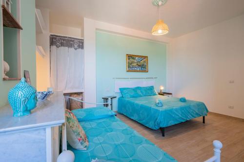 a blue bedroom with a bed and a couch at PIAZZA LAURINO Apartments in Laurino