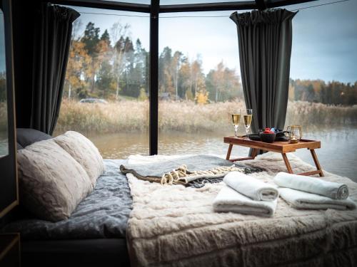 een slaapkamer met een bed met een tafel en een raam bij Aurora Igloo Porvoo in Porvoo